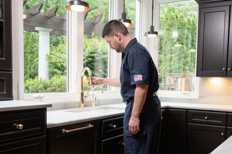 Hero Home Services plumber checking the faucet at a kitchen sink